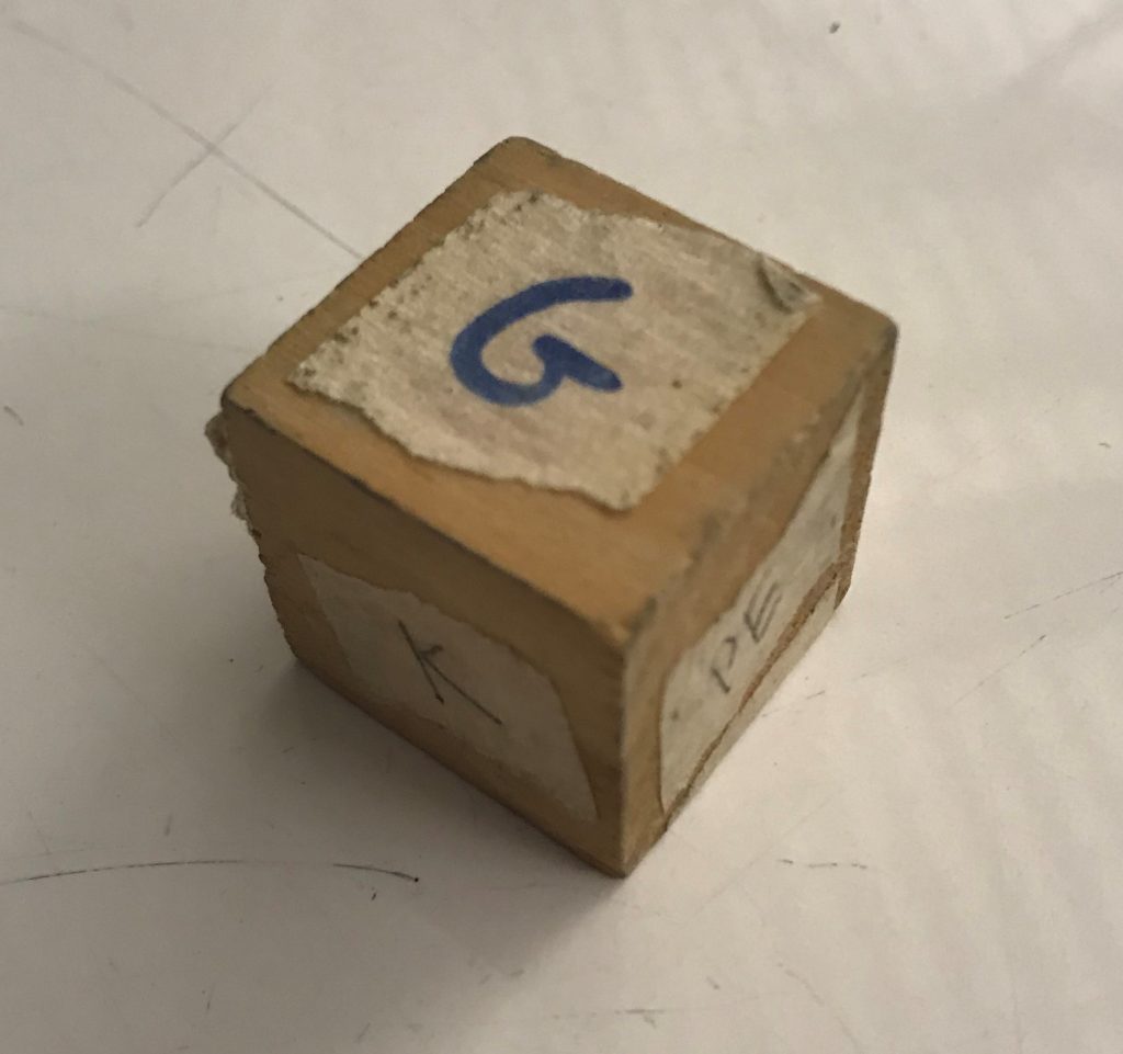 A wooden energy cube. Each face has a different label for a different type of energy.